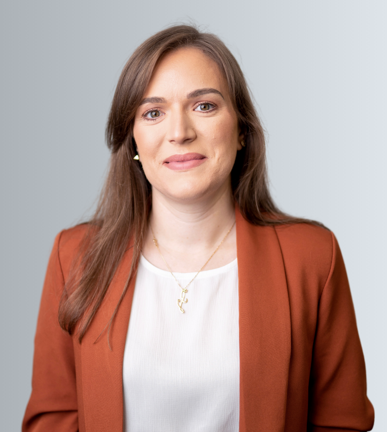 photo of Lara De Tomasi wearing a burnt orange blazer and white top